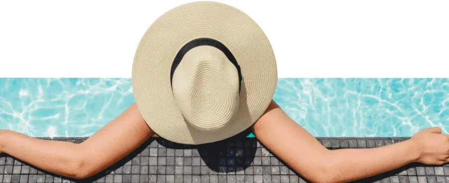 Persona relajándose en la piscina con sombrero de ala ancha en Unique Residencial, obra nueva en Zaragoza.